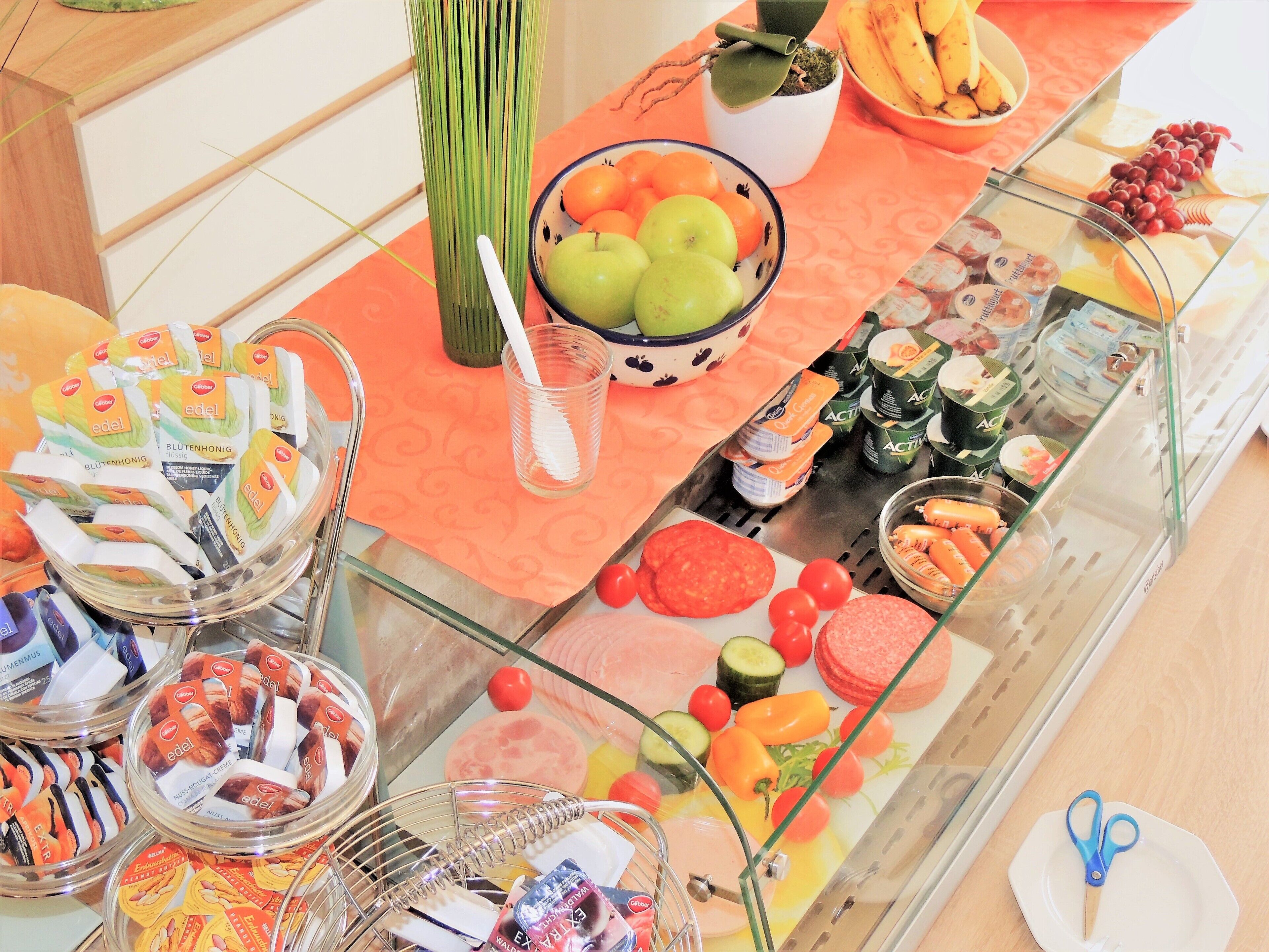 A buffet with various food items including fruits, vegetables, and packaged snacks.