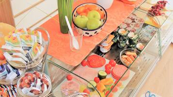 A buffet with various food items including fruits, vegetables, and packaged snacks.