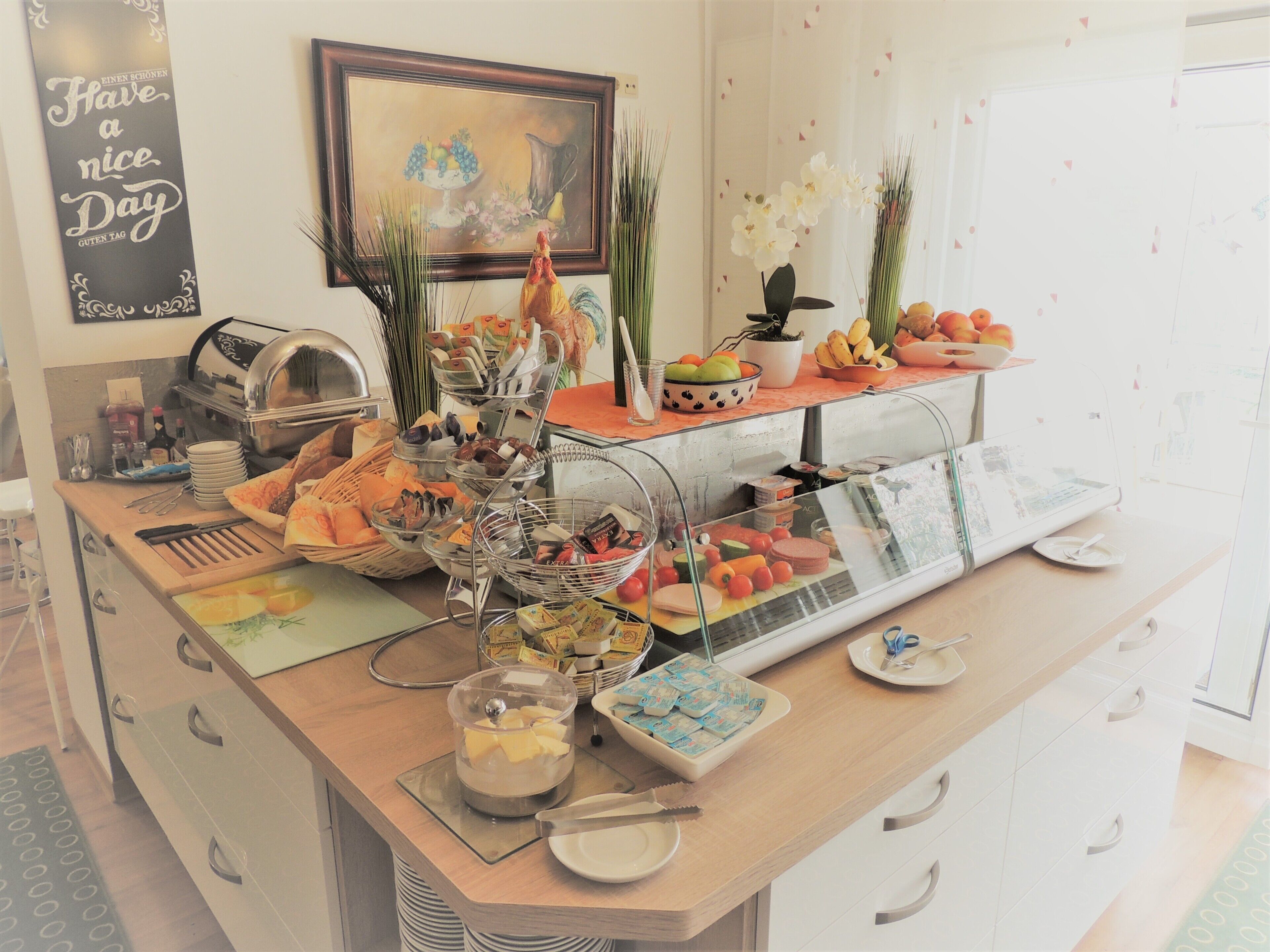 Un buffet proposant divers plats, une machine à café et un panneau décoratif accroché au mur.