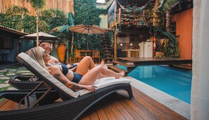 A poolside area with lounge chairs, a wooden deck, and a pool. - Pousada Arraial Inn (Arraial do Cabo)