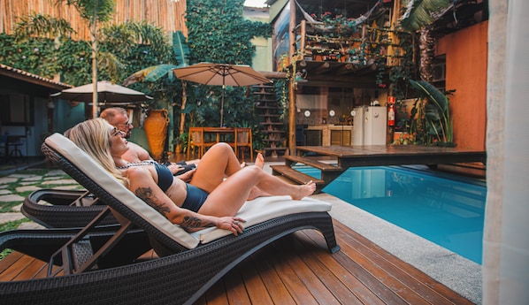 室外游泳池，開放時間為 10:30 至 19:30，提供日光浴躺椅