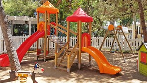 A playground with slides, climbing structures, and a small green building. - Baia dei Lombardi (Vieste)