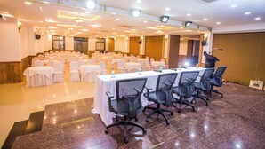 A conference room with a long table, chairs, and rows of white chairs. - Hotel Menino Executive (Ponda)