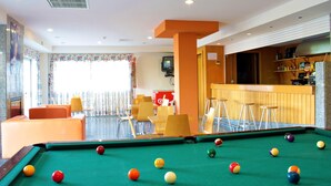 A pool table with balls, a bar area, and seating with a view. - HI Foz Côa - Pousada de Juventude - Hostel (Vila Nova de Foz Coa)