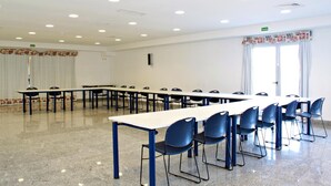 A conference room with long tables and chairs, white walls, and a large window with curtains. - HI Foz Côa - Pousada de Juventude - Hostel (Vila Nova de Foz Coa)