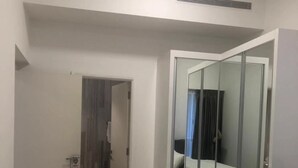 Una habitación de hotel con una cama, un espejo y una puerta que da a otra habitación.