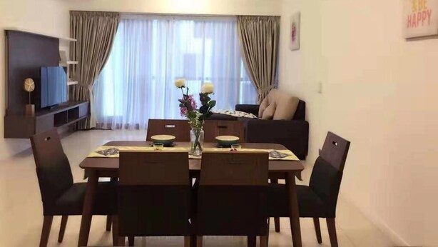 Un comedor con una mesa dispuesta para cuatro personas, un ventilador de techo y un sofá al fondo.