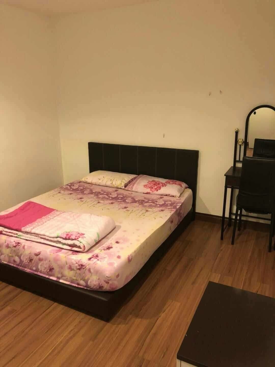 Un lit simple avec une couvre-lit à motifs floraux, une table de chevet et une chaise.