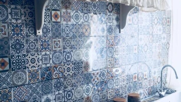 A kitchen with patterned tiles, a gas stove, and a sink. - B&B Le Rose (Salerno)