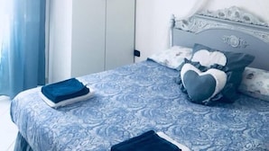 A bedroom with a bed, a wardrobe, and a hanging light fixture. - B&B Le Rose (Salerno)