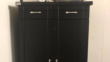 Guarda-roupa preto com duas portas e duas gavetas, cada uma com puxador prateado.