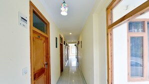 Un pasillo con puertas de madera, un accesorio de iluminación y una ventana.