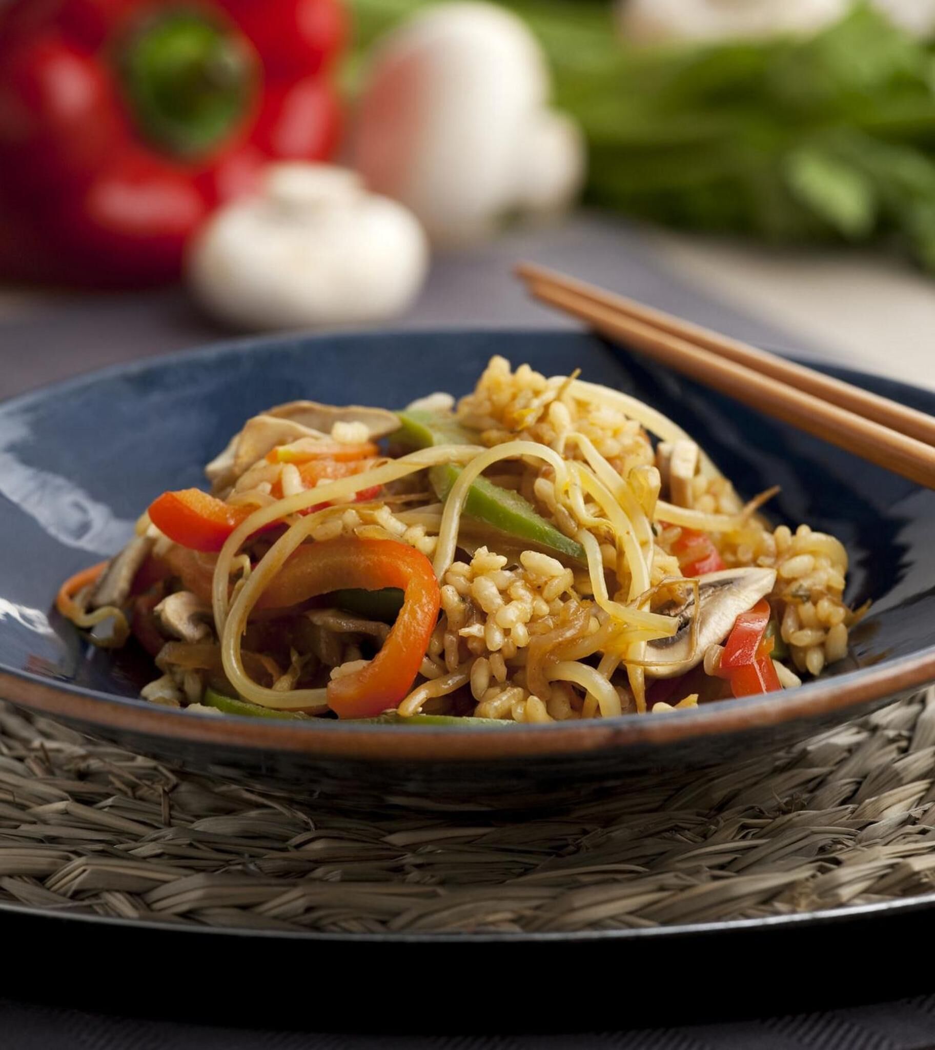 A plate of stir-fried noodles with vegetables and mushrooms.