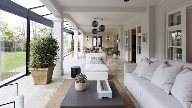 A spacious patio with a white sofa, a coffee table, and a potted plant. - Arambrook Boutique Hotel (Cape Town)