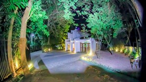 A pathway leading to a building with a traditional architectural style, surrounded by trees and illuminated by ambient lighting. - Cinnamon Airport Residencies (Seeduwa - Katunayake)