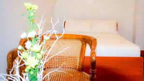 A wooden chair with a woven backrest and a white mattress in a room with plain walls. - Cinnamon Airport Residencies (Seeduwa - Katunayake)