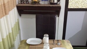 A small dining table with two white plates, a glass pitcher, and a bottle of water. - Cinnamon Airport Residencies (Seeduwa - Katunayake)