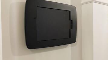 A black, rectangular object mounted on a white wall with a decorative molding at the top.