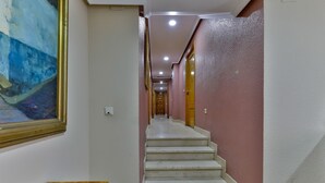 Un passadís amb una escala que condueix a una porta al final.
