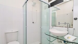 Une salle de bain moderne avec une douche à parois de verre, un lavabo en verre et des toilettes.