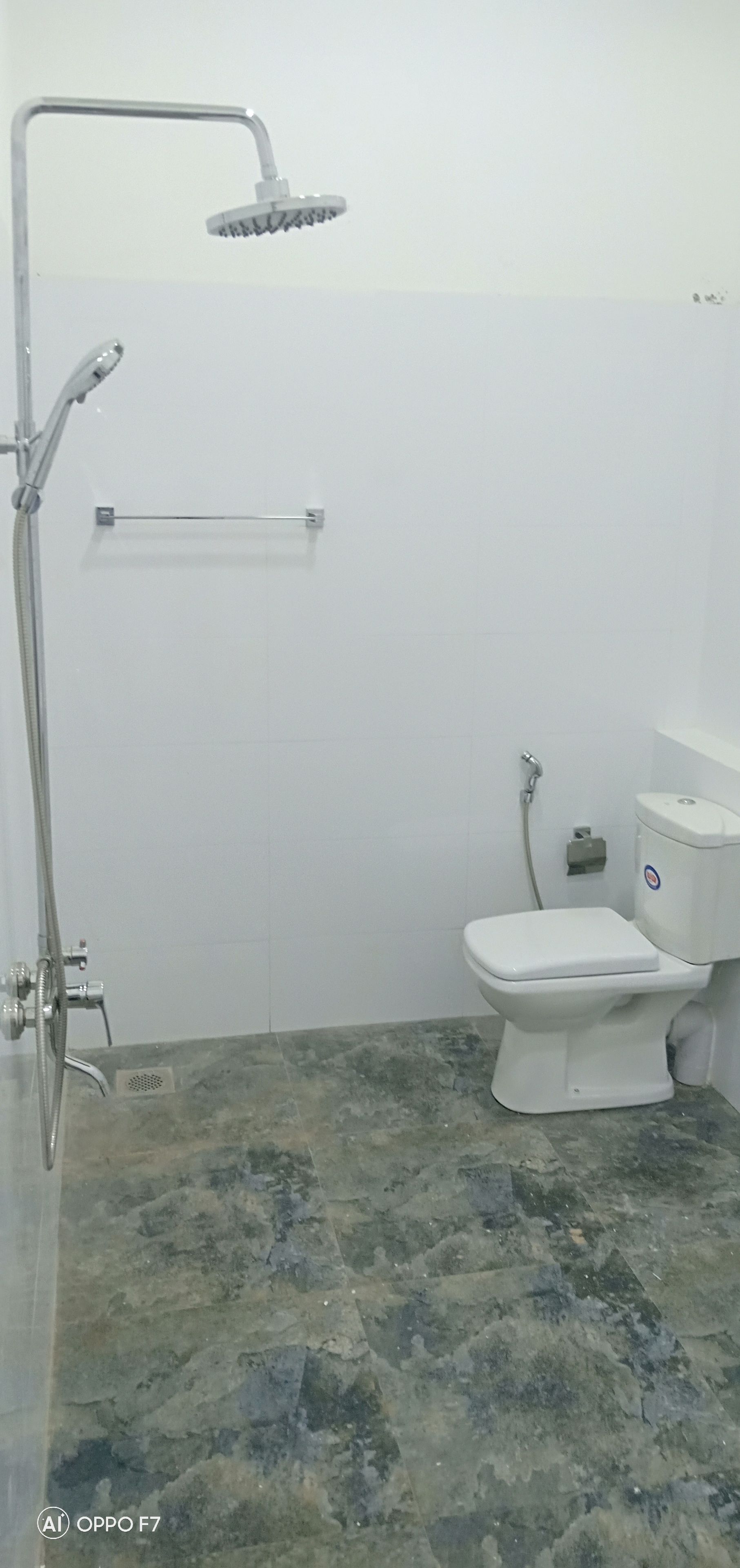 Un baño con ducha, inodoro y toallero.