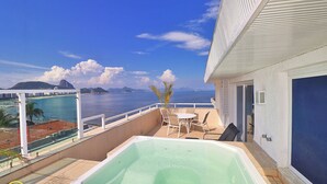 Ein Balkon mit Whirlpool, Tisch und Stühlen mit Blick aufs Meer.