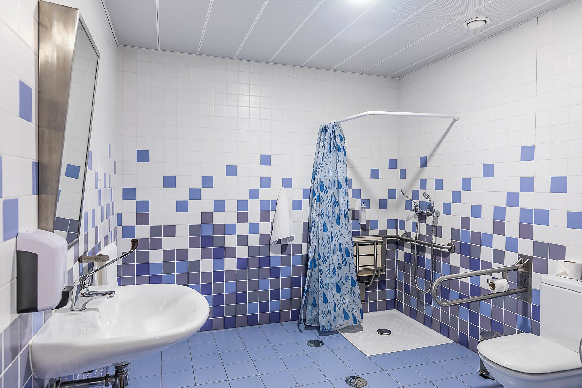 A bathroom with a shower, a sink, and a toilet.