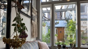 Un salón acogedor con un sofá a rayas, una mesita y un ventanal con vistas al exterior.