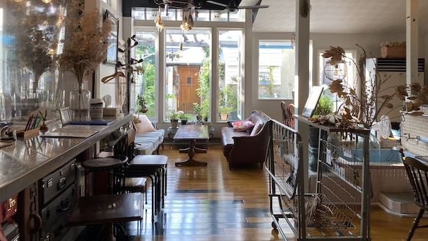 Una cocina amplia con una isla central, ventanas grandes y una combinación de decoración moderna y rústica.