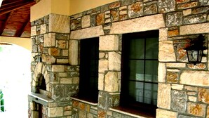 A stone exterior wall with two windows and a stone fireplace. - Villa Manzara (Ortaca)