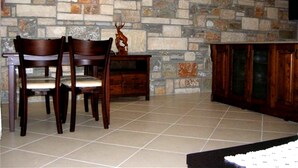 A stone wall with a fireplace, wooden chairs, a table, and a cabinet. - Villa Manzara (Ortaca)