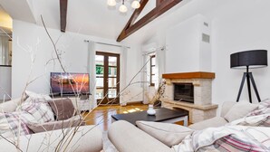 A modern living room with a fireplace, a sofa, a coffee table, and a TV.