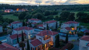 Un barrio residencial con varias casas, una piscina y vistas del paisaje circundante.