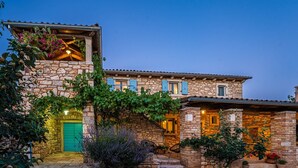 A stone house with a green door, multiple windows, and a well-maintained garden. - Spacious and comfortable Villa in the heart of Barban (Grandici)