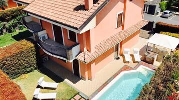 Relax by the pool surrounded by lush gardens and a balcony.