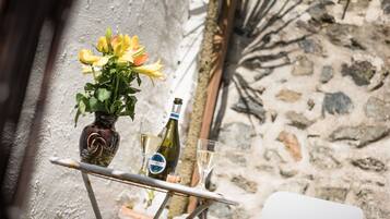 Ein Tisch mit einer Vase voller gelber Blumen, einer Prosecco-Flasche und einem Weinglas.