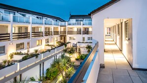 A multi-level hotel with balconies, outdoor plants, and a well-lit corridor. - Atlantic Blue Overlooks Porthmeor Beach in St Ives. Very Close to Town Centre, Shops, Restaurants. Free Parking. Free Wifi (St Ives)