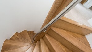 A wooden spiral staircase with a metal handrail. - Pencroft, a Spacious House With Garden, Free Parking for 2 Cars. Walking Distance to Beach and St Ives. Local Restaurants Very Nearby. Free Wifi (St Ives)