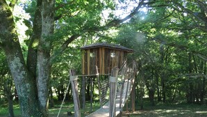 A wooden treehouse with a rope bridge, surrounded by dense forest. - Tramois - Chambres d'hôtes (Donzy)