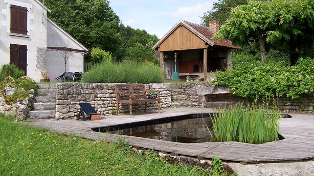 A rustic house with a stone wall and a wooden deck. - Tramois - Chambres d'hôtes (Donzy)