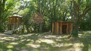 A rustic wooden cabin with a thatched roof, surrounded by a forested area. - Tramois - Chambres d'hôtes (Donzy)
