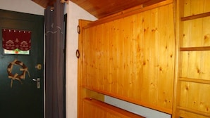 Een houten deur met een krans, een donkergroene deur, en een gordijn.