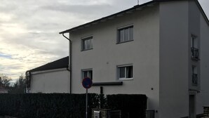 A two-story building with a no parking sign, a gated entrance, and a mailbox. - Appartement- Steinkirchner (Straubing)