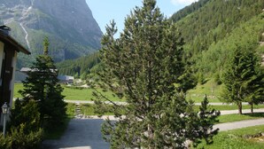 A mountain landscape with a building and a road leading to it.