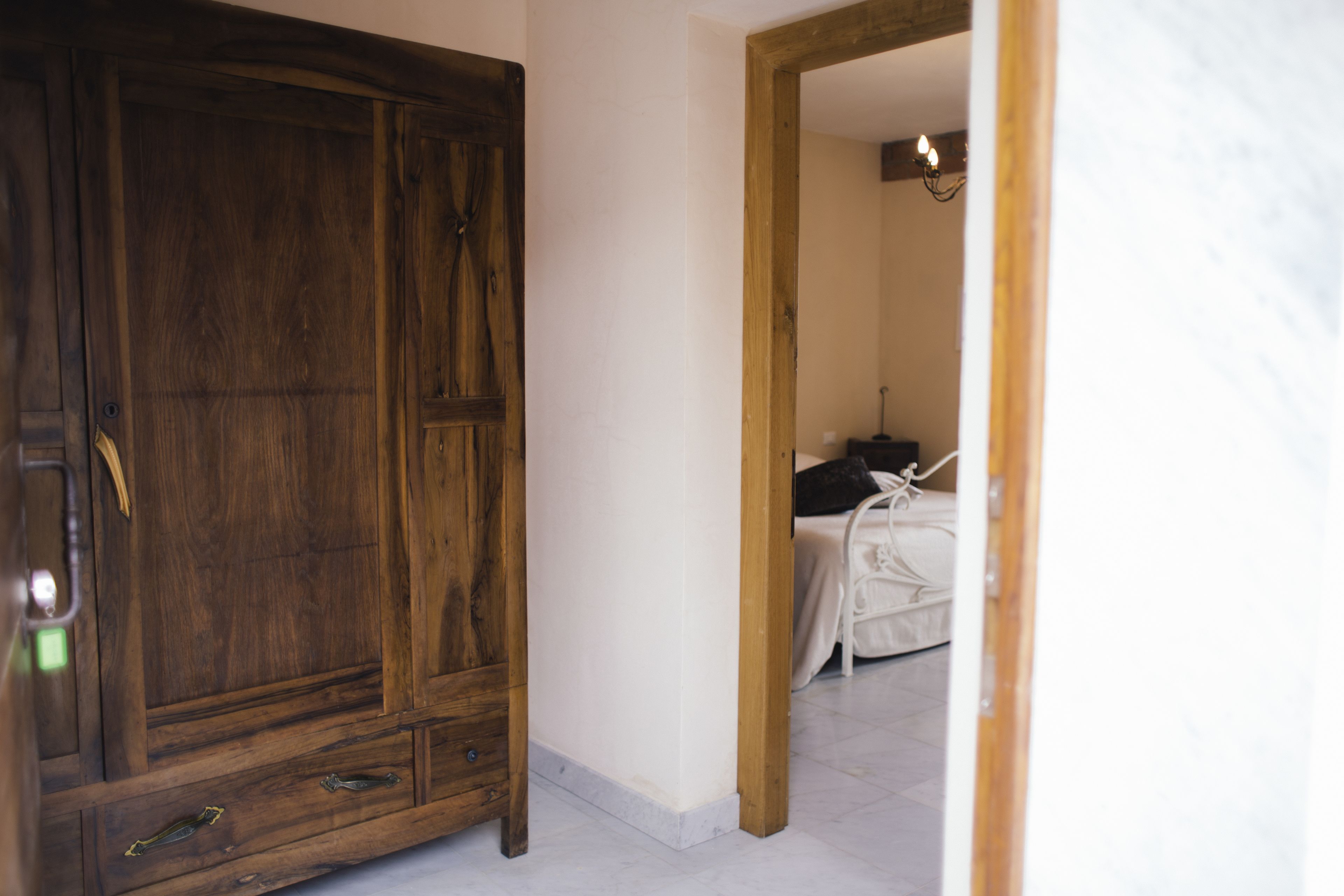 Un armario de madera en una habitación con una cama y un espejo.