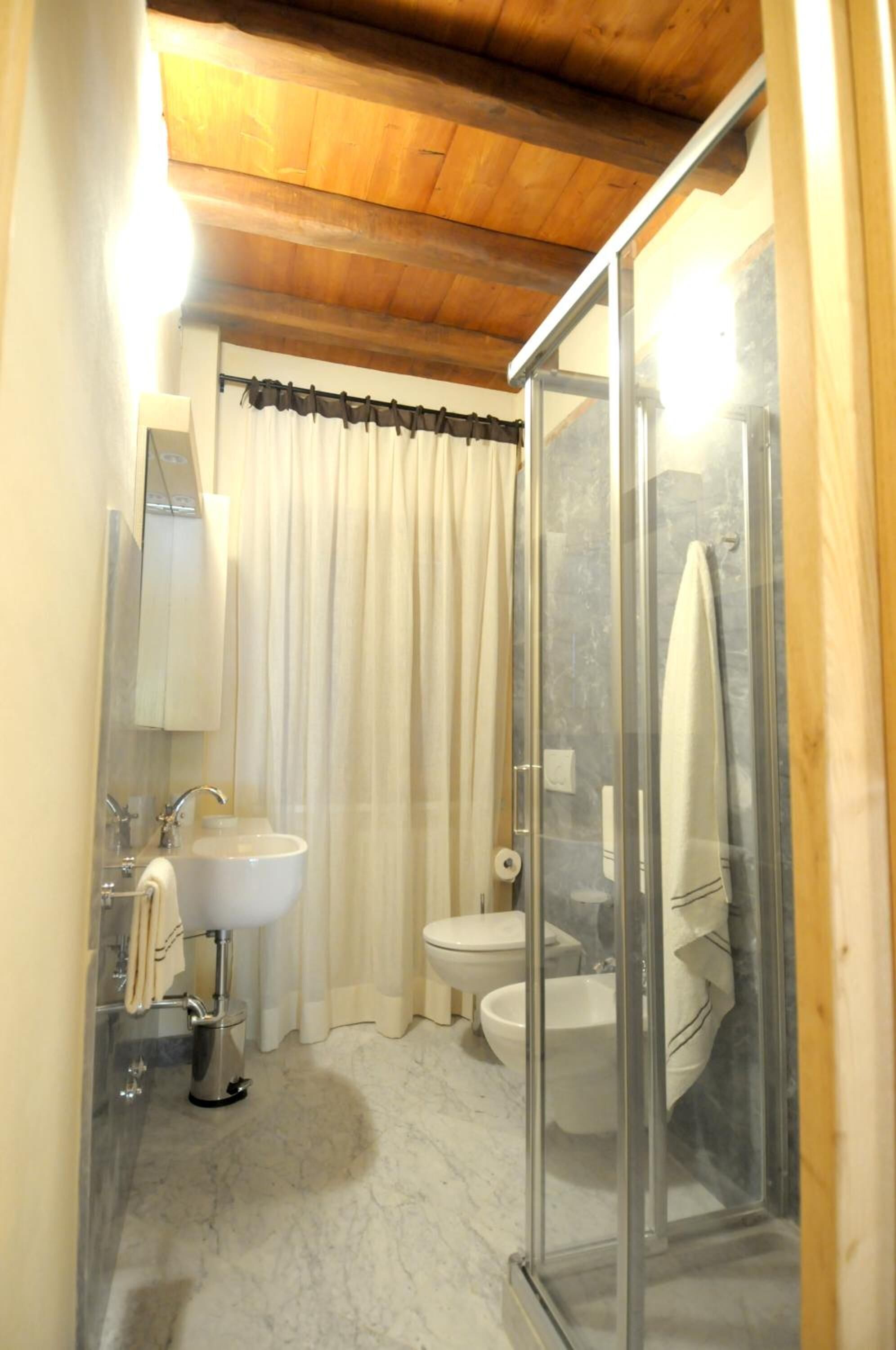 Une salle de bain avec une douche à parois de verre, un lavabo et des toilettes.