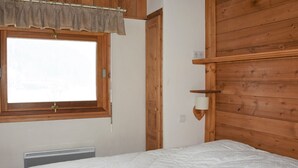 A room with a bed, a window with a curtain, a radiator, and wooden walls. - Comfortable 4-room duplex, 6 pers, garage, Pralognan-la-Vanoise (Pralognan-la-Vanoise)