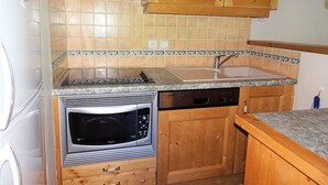 A compact kitchen with wooden cabinets, a built-in microwave, and a dishwasher. - Comfortable 4-room duplex, 6 pers, garage, Pralognan-la-Vanoise (Pralognan-la-Vanoise)