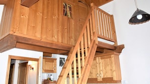 A wooden loft bedroom with a staircase, wooden beams, and a hanging light fixture. - Comfortable 4-room duplex, 6 pers, garage, Pralognan-la-Vanoise (Pralognan-la-Vanoise)