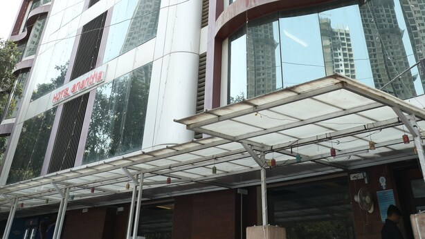 A modern hotel with a curved facade, large windows, and a covered entrance area. - Hotel Anantha Executive Suites (Mumbai)